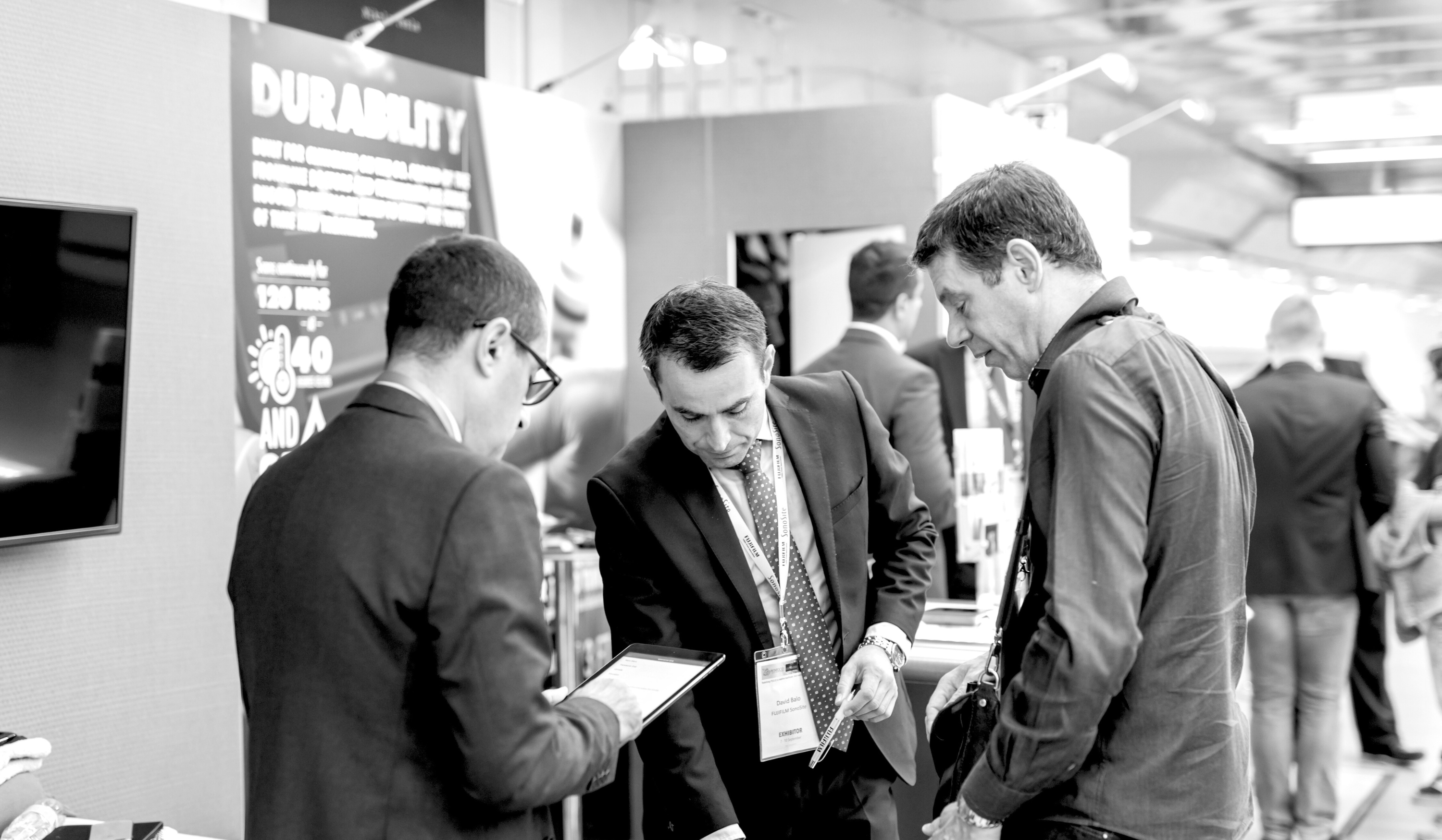 Illustration of professionals networking at an event, contrasting with digital ads on a screen, symbolising the power of events in marketing.